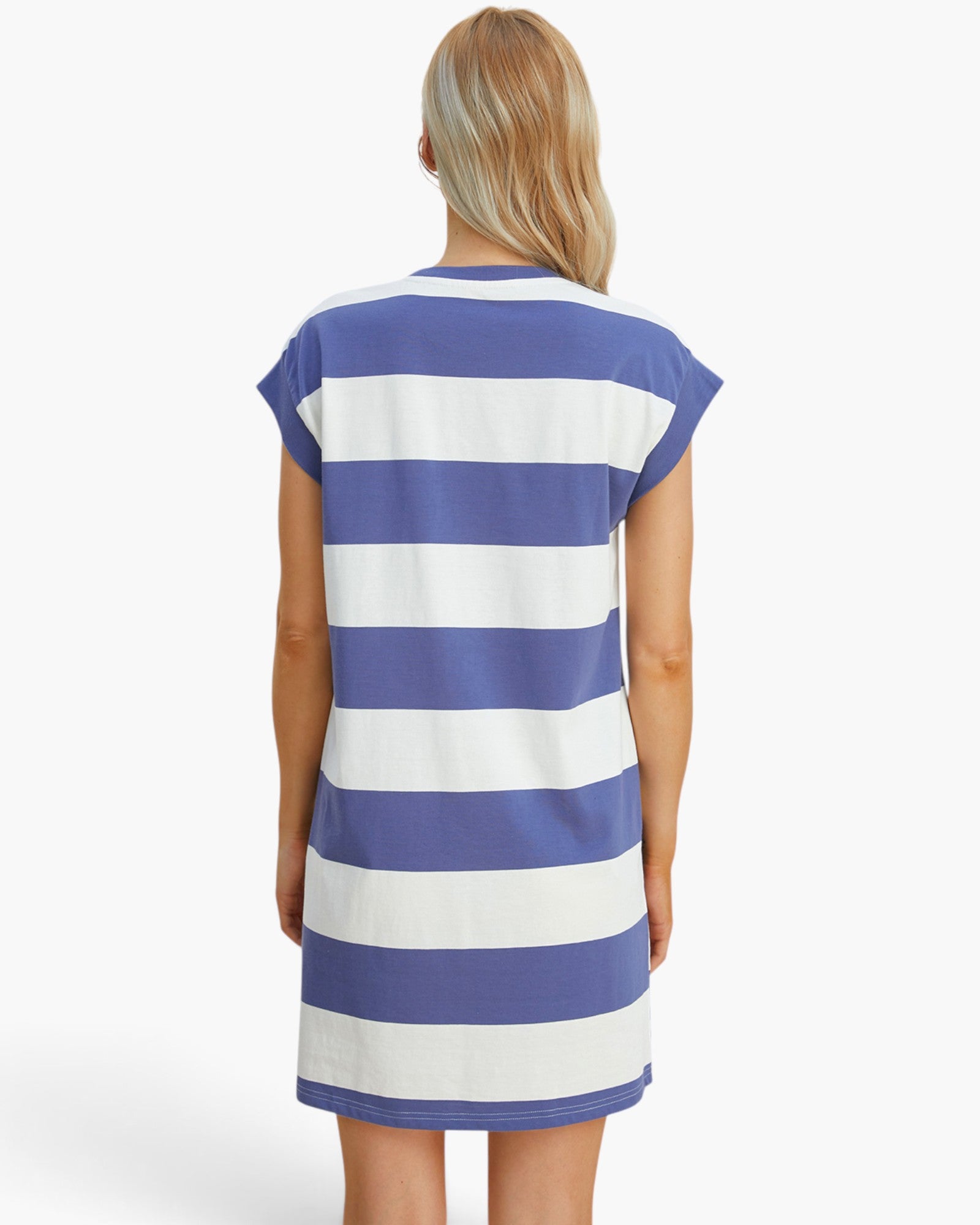 A woman viewed from the back wearing a short-sleeve tunic dress with horizontal blue and white stripes, set against a plain light gray studio background.