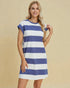 Woman wearing a blue and white striped dress against a beige background