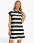 A woman wearing a short-sleeve black and white horizontally striped t-shirt dress, posing against a clean white studio background.