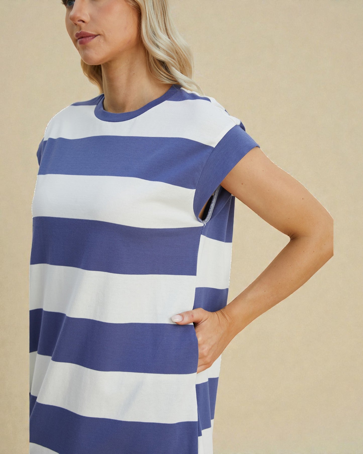 Woman wearing a blue and white striped dress against a beige background