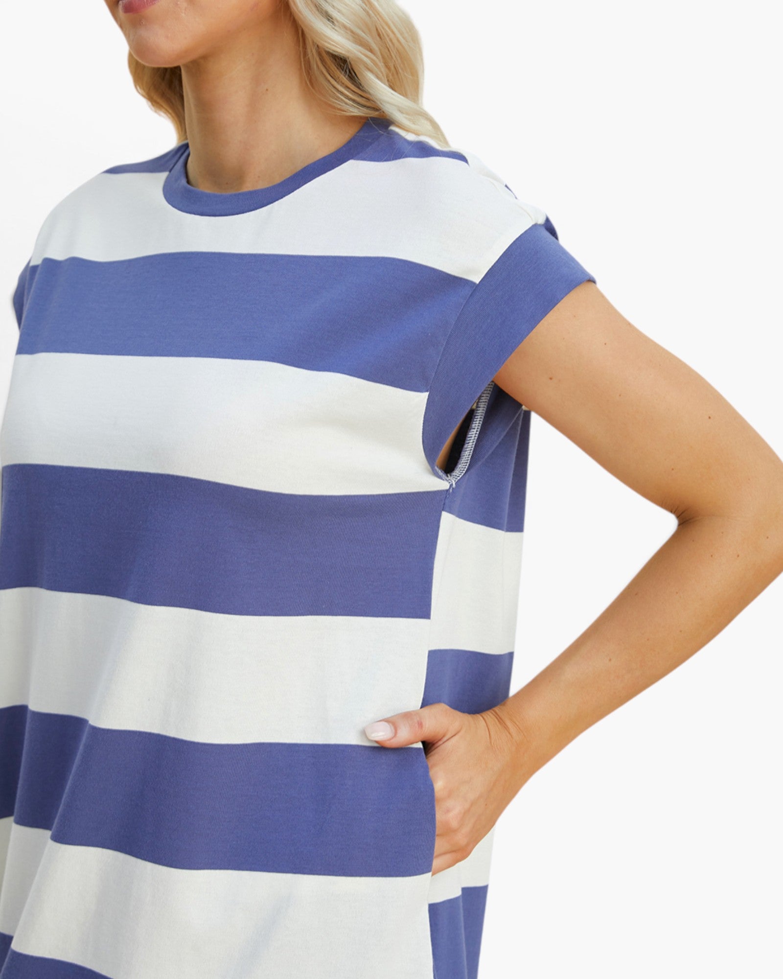 A close-up of a woman wearing a short-sleeve tunic top with horizontal blue and white stripes, set against a plain white background.