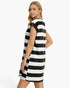 A woman modeling a sleeveless, A-line shift dress with bold horizontal black and white stripes, photographed against a clean white studio background.