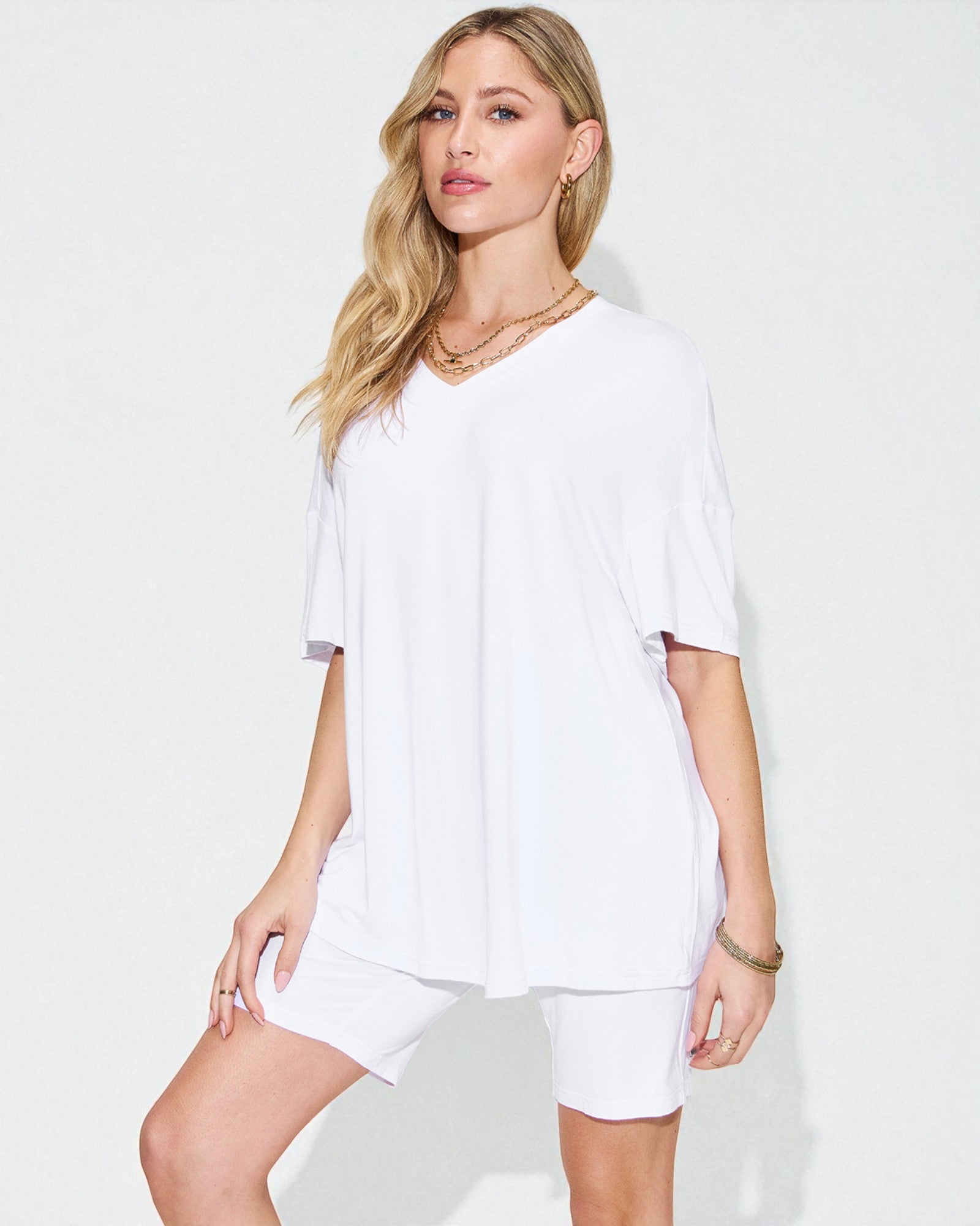 Woman wearing a white outfit on a plain background