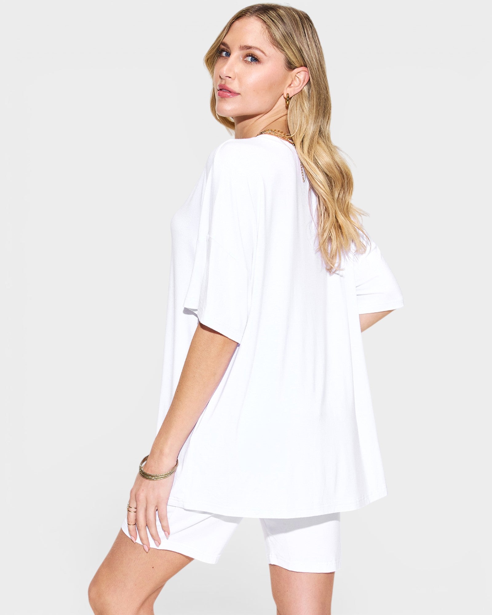 Woman wearing a white outfit on a plain background