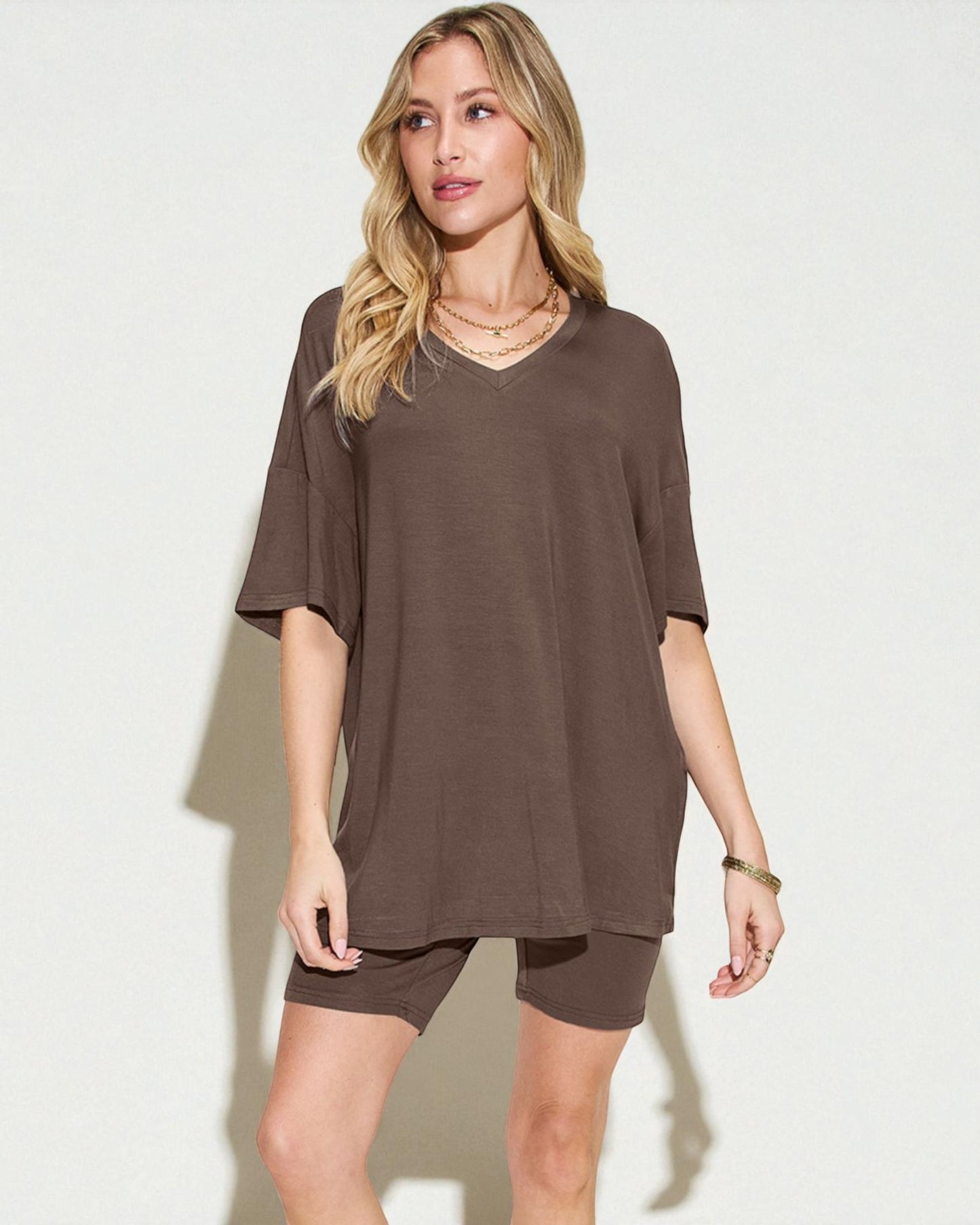 Woman wearing a brown oversized t-shirt and shorts set on a white background