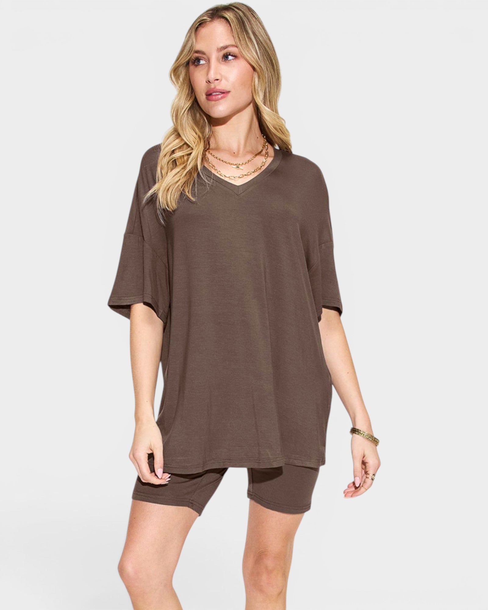 Woman wearing a brown oversized t-shirt and shorts on a white background