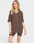 Woman wearing a brown oversized t-shirt and shorts on a white background