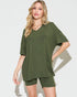 Woman wearing an olive green t-shirt and shorts set on a white background