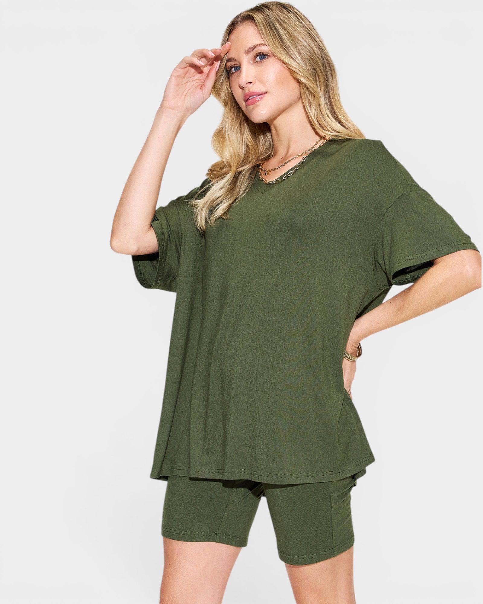 Woman wearing an olive green outfit on a white background