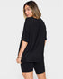 Woman wearing a black outfit on a plain background