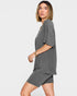 Woman wearing a gray outfit on a plain background