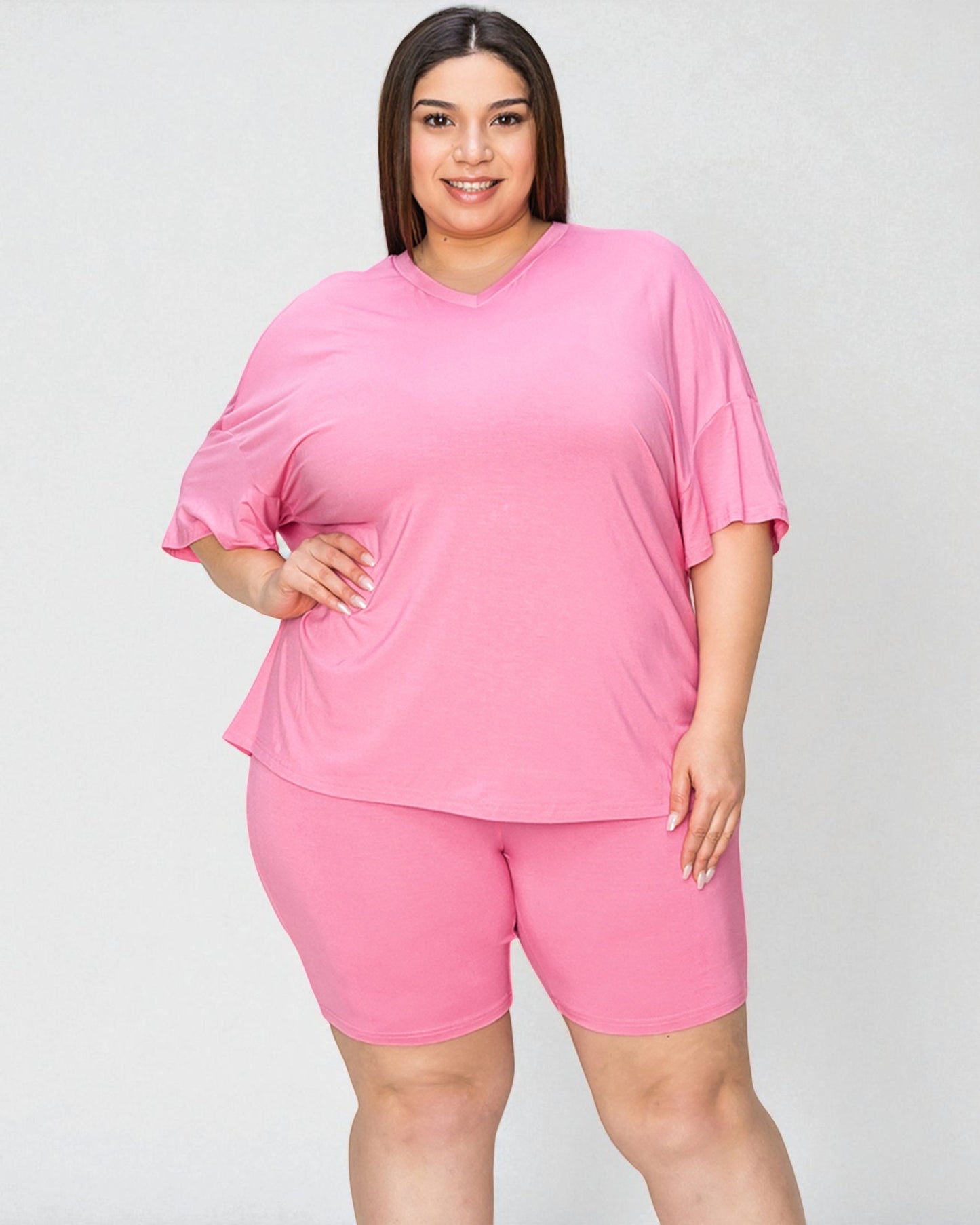 Woman wearing a pink outfit on a plain background