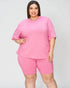 Woman wearing a pink outfit on a plain background