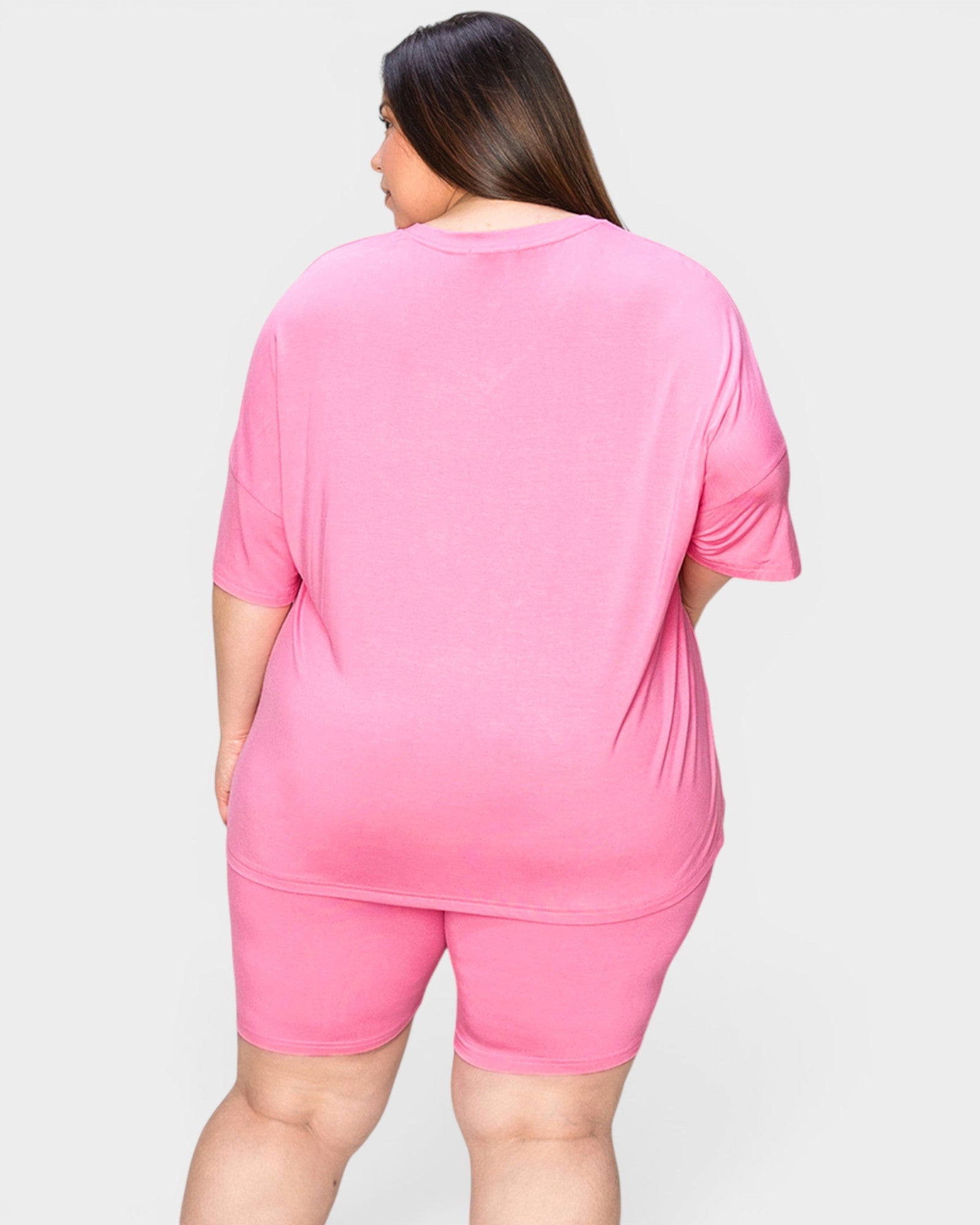 Person wearing a pink outfit on a plain background