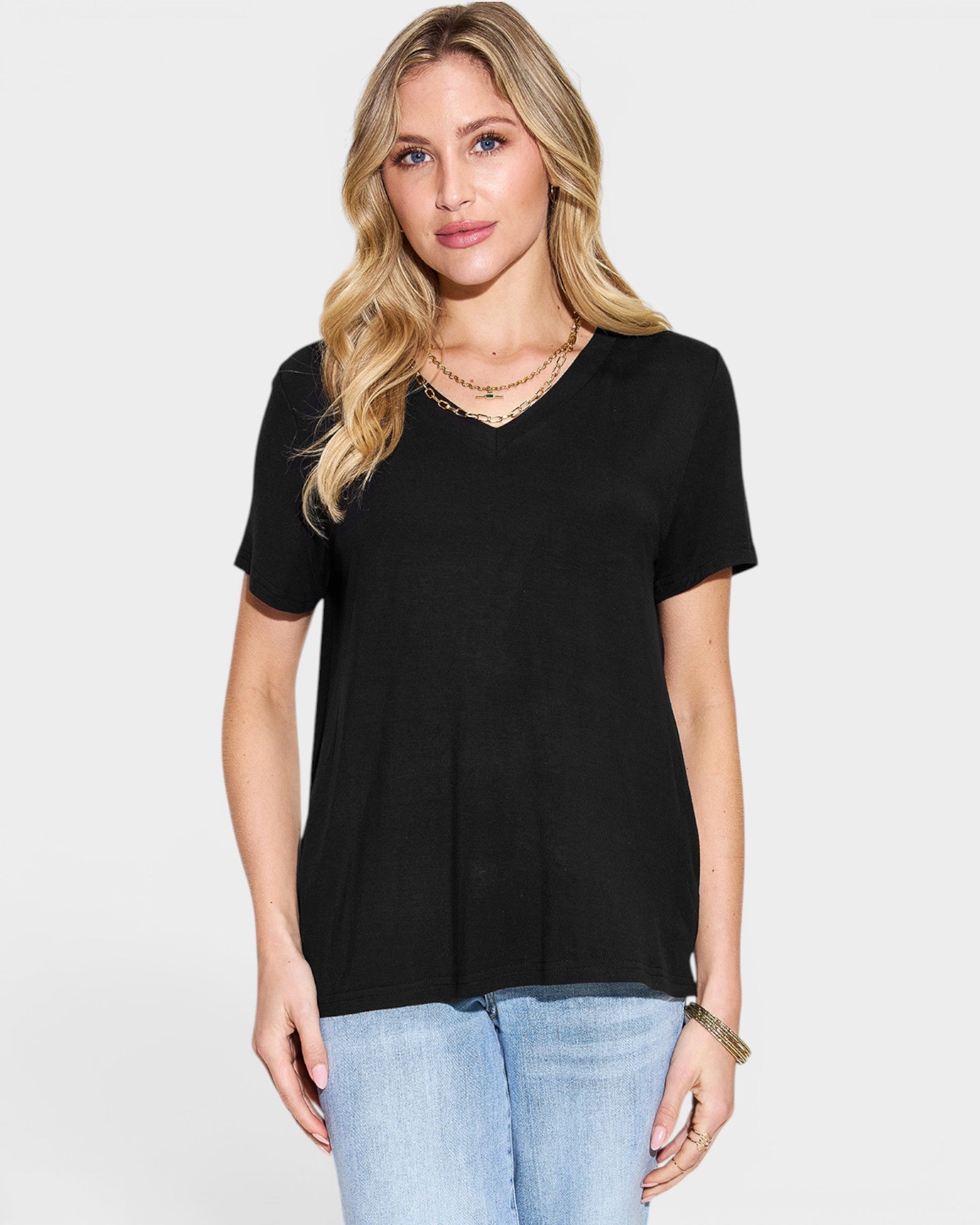 Woman wearing a black t-shirt and light blue jeans on a white background