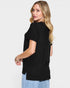 Woman wearing a black t-shirt and light blue jeans on a white background