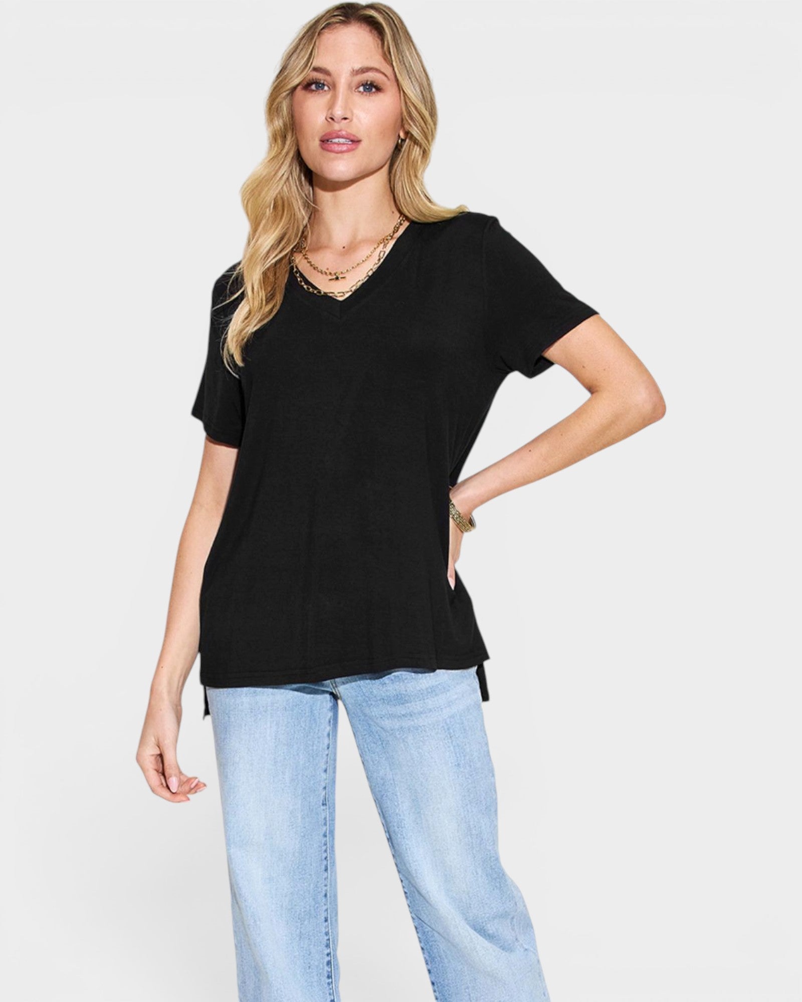 Woman wearing a black t-shirt and light blue jeans on a white background