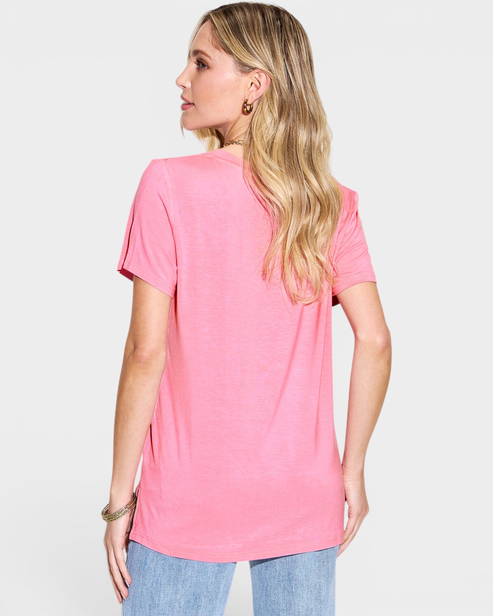Woman wearing a pink t-shirt on a plain background