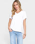 Woman wearing a white t-shirt and light blue jeans on a plain background