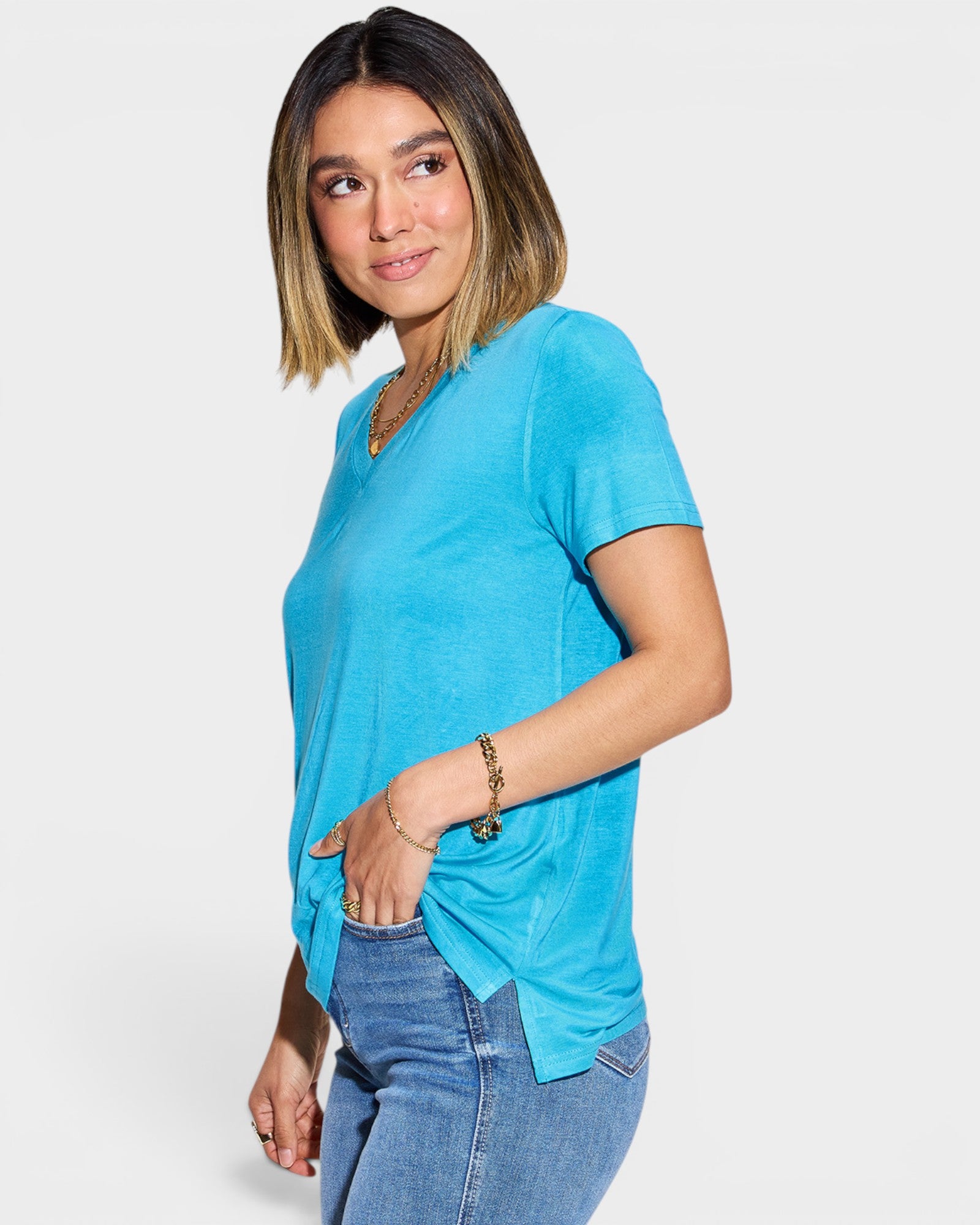 Woman wearing a blue t-shirt and jeans on a white background