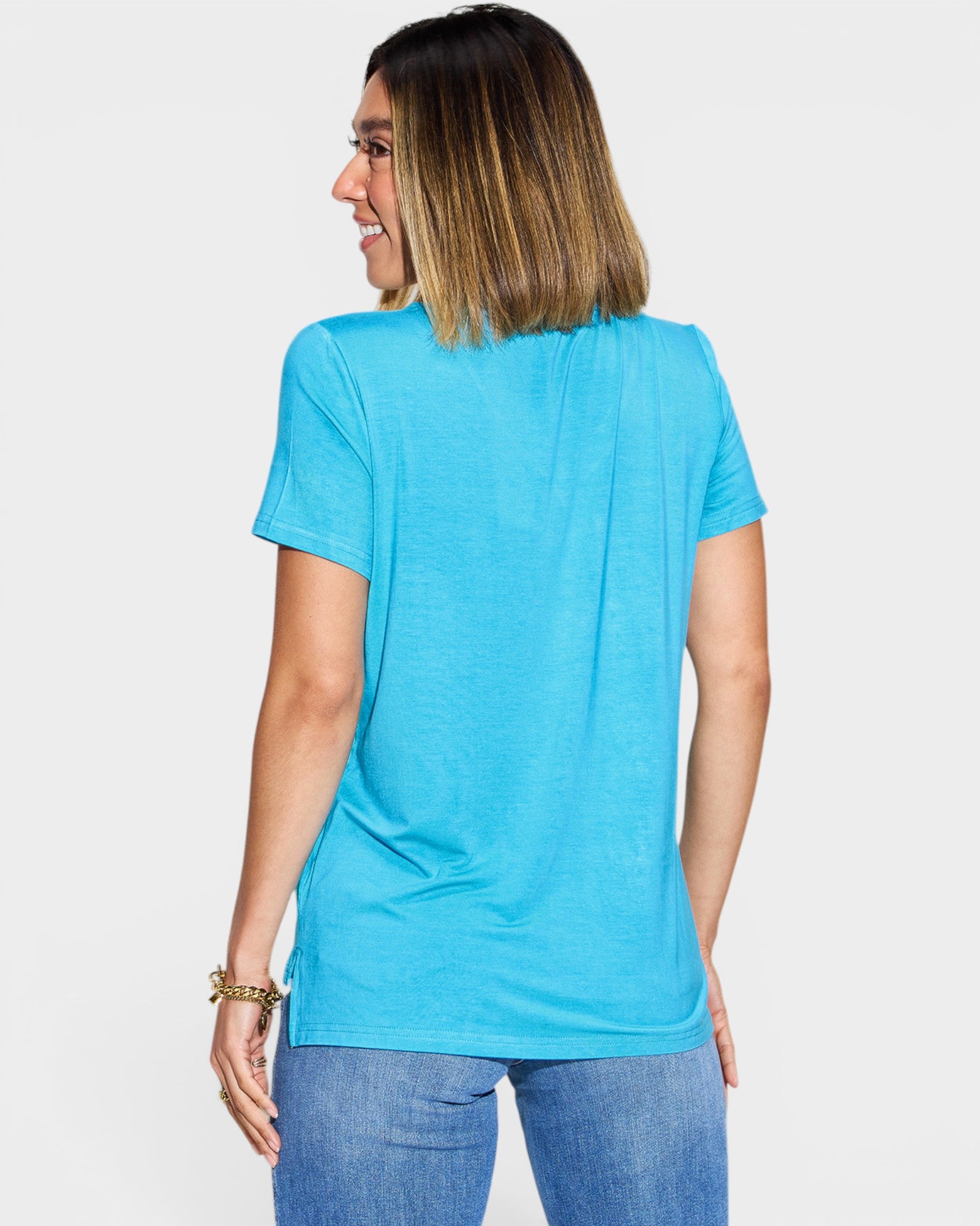 Woman wearing a blue t-shirt and jeans on a white background