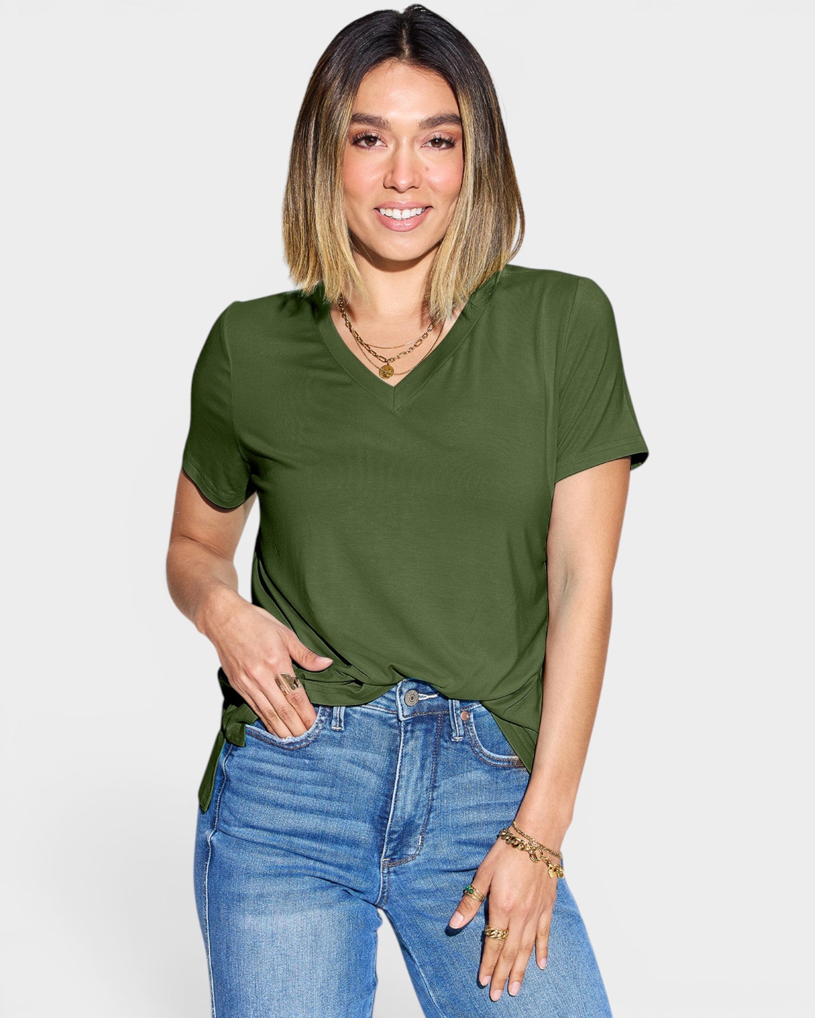Woman wearing an olive green t-shirt and blue jeans on a white background
