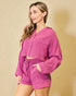 Woman wearing a pink textured outfit against a beige background