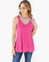 A woman modeling a bright pink sleeveless tank top with a scalloped lace V-neckline, paired with blue jeans against a plain white background.