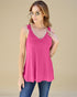 Woman wearing a pink tank top with lace details on a beige background