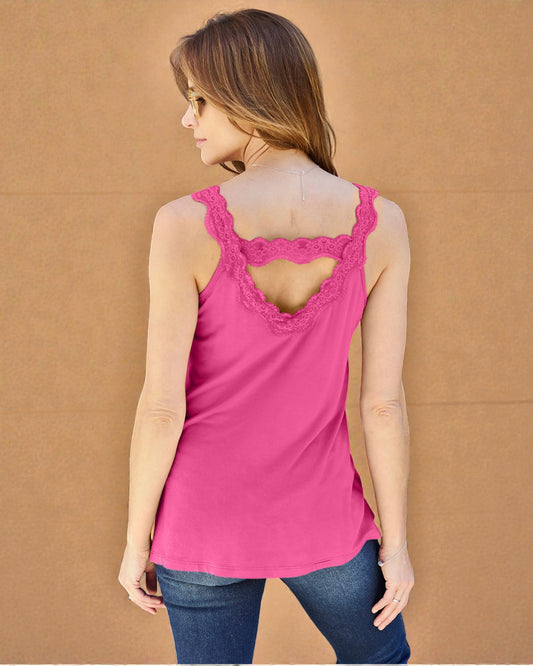 Woman wearing a pink tank top with lace details on a brown background