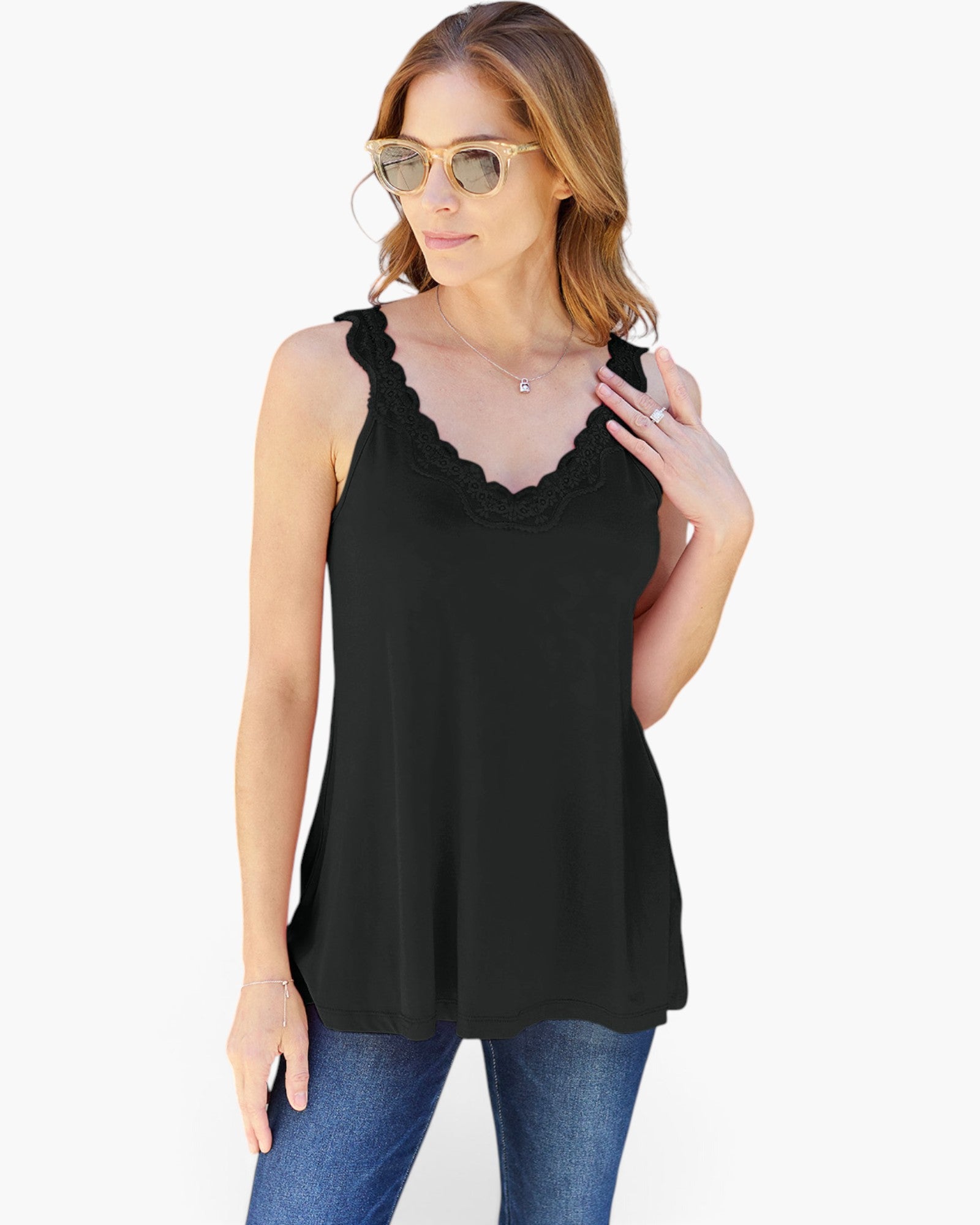 A woman modeling a black sleeveless top with a scalloped lace V-neckline, paired with blue jeans and gold-framed sunglasses, against a plain white background.