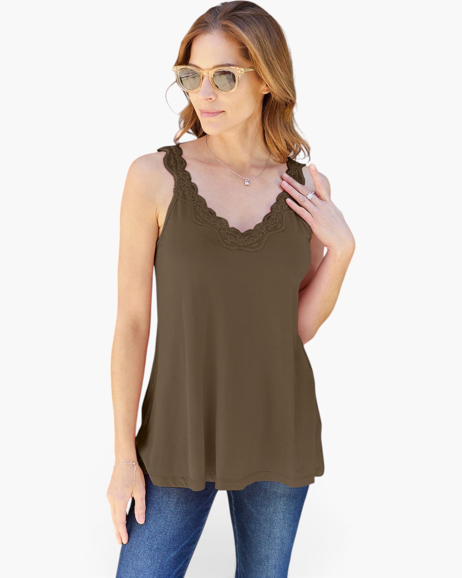 A woman modeling a sleeveless olive brown tank top with a scalloped lace V-neckline, paired with blue jeans against a plain white background.