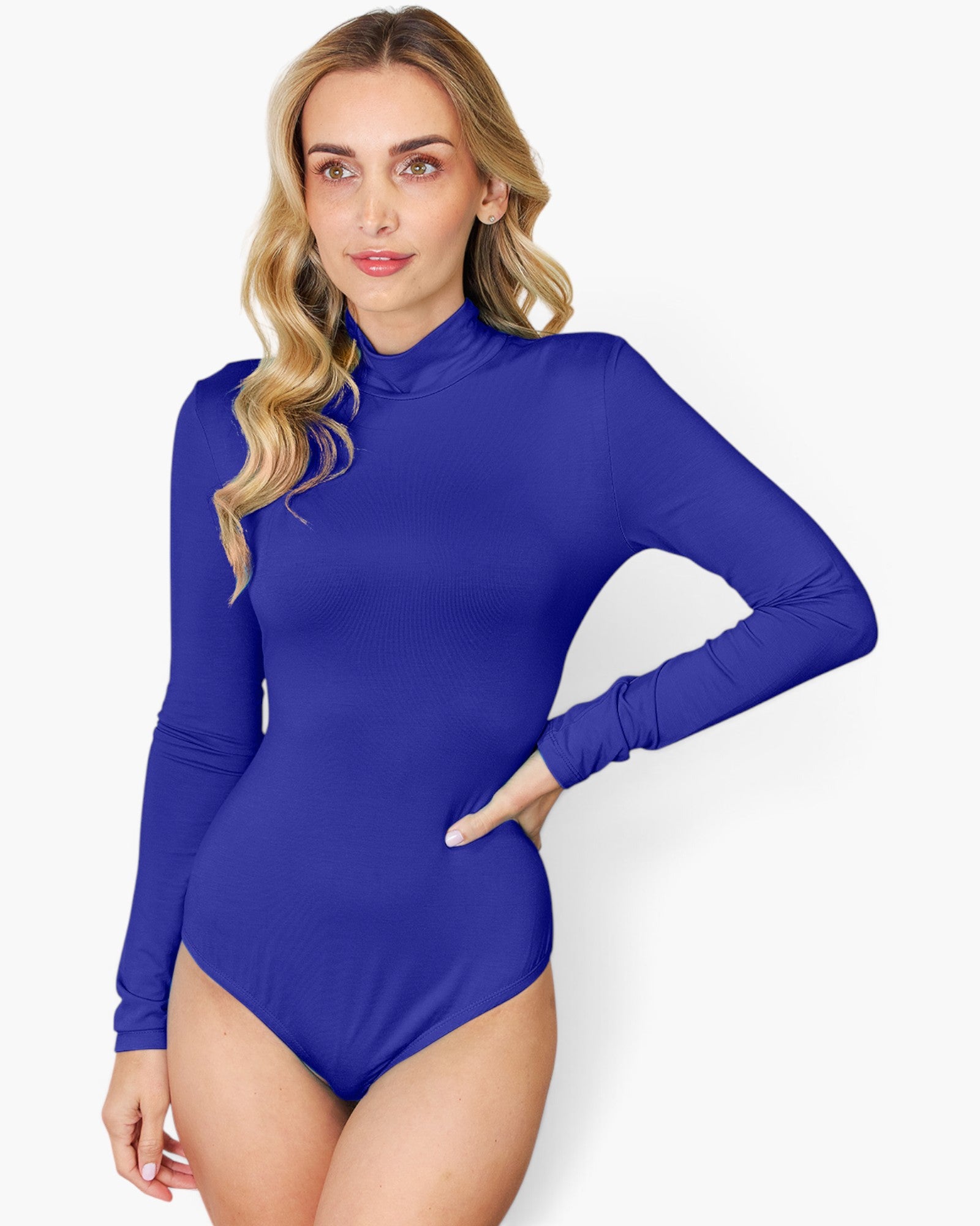 A woman modeling a royal blue long-sleeve mock neck bodysuit against a plain light gray background.