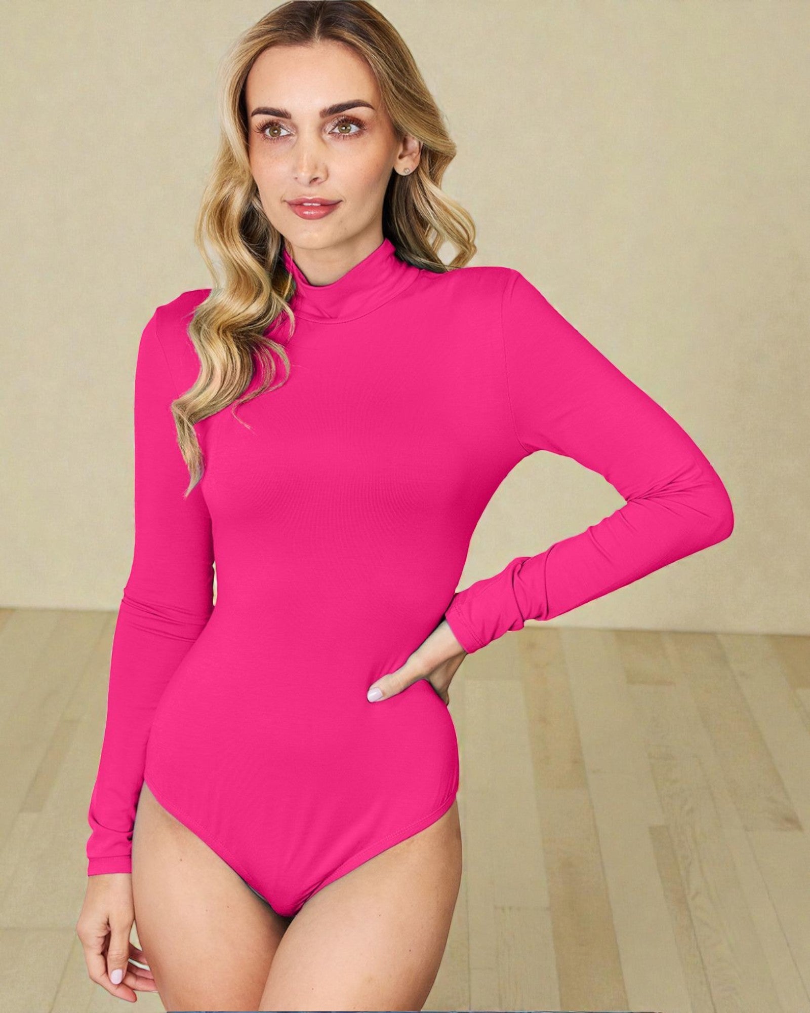 Woman wearing a bright pink long-sleeve bodysuit against a beige background