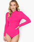 A woman modeling a bright pink long-sleeve mock neck bodysuit against a light gray studio background.