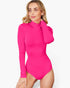 A woman modeling a bright pink long-sleeve bodysuit with a mock neck, photographed against a clean light gray studio background.