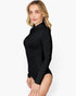 A woman modeling a black long-sleeve mock neck bodysuit against a plain white studio background.