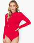 A woman modeling a bright red long-sleeve bodysuit with a mock neck, photographed against a clean light gray studio background.