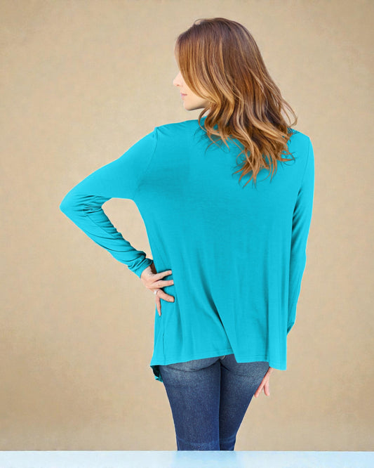 Woman wearing a turquoise long-sleeve top against a beige background