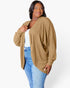 A woman modeling a tan ribbed open-front cardigan over a white top and blue jeans, photographed against a clean white studio background.