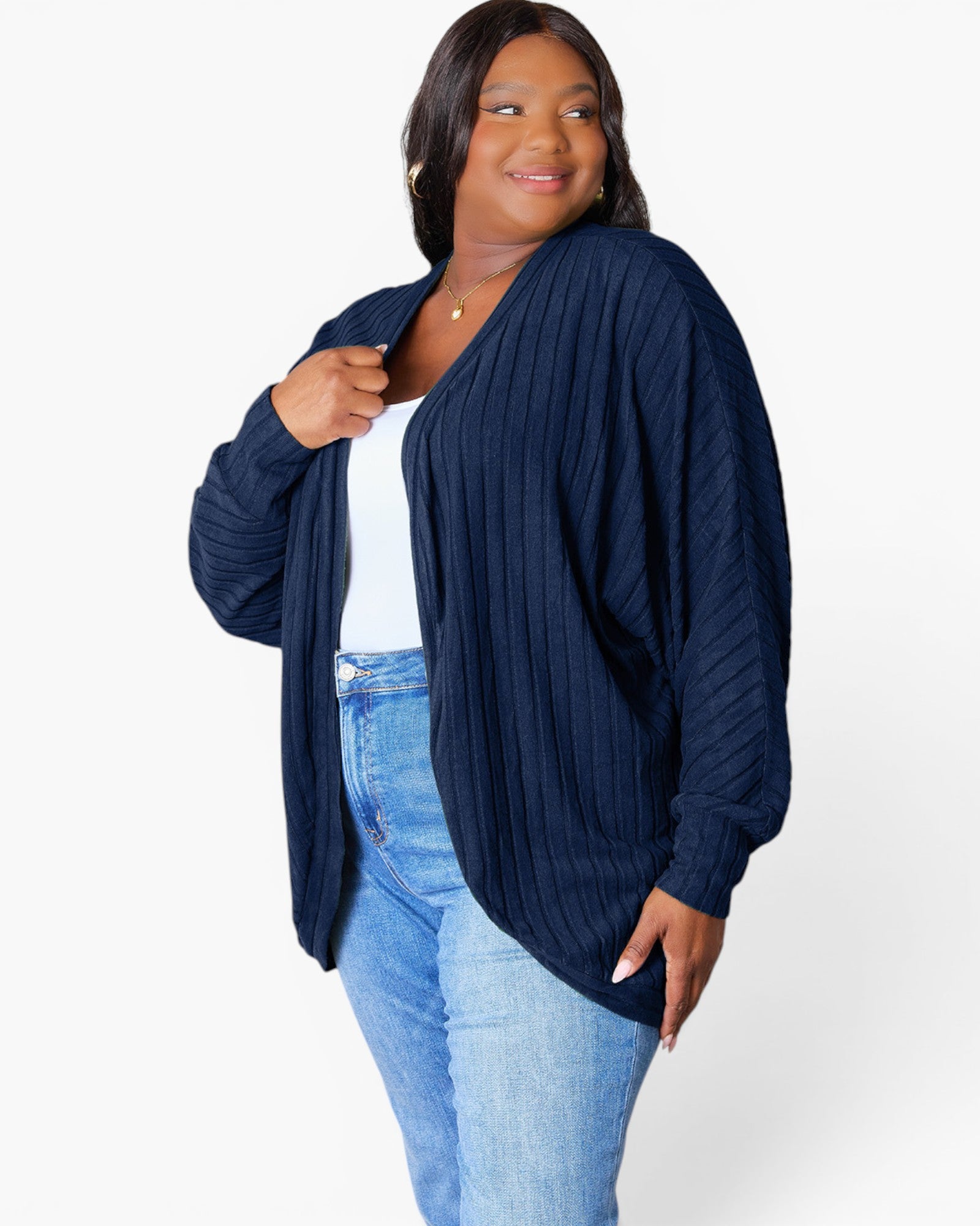A woman modeling a navy blue ribbed open-front cardigan over a white top and light blue jeans, photographed against a clean white studio background.
