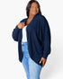 A woman modeling a navy blue ribbed open-front cardigan over a white top and light blue jeans, photographed against a clean white studio background.