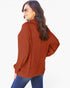 A woman wearing a rust-orange ribbed knit long-sleeve top and blue jeans, photographed from the back against a plain white background.