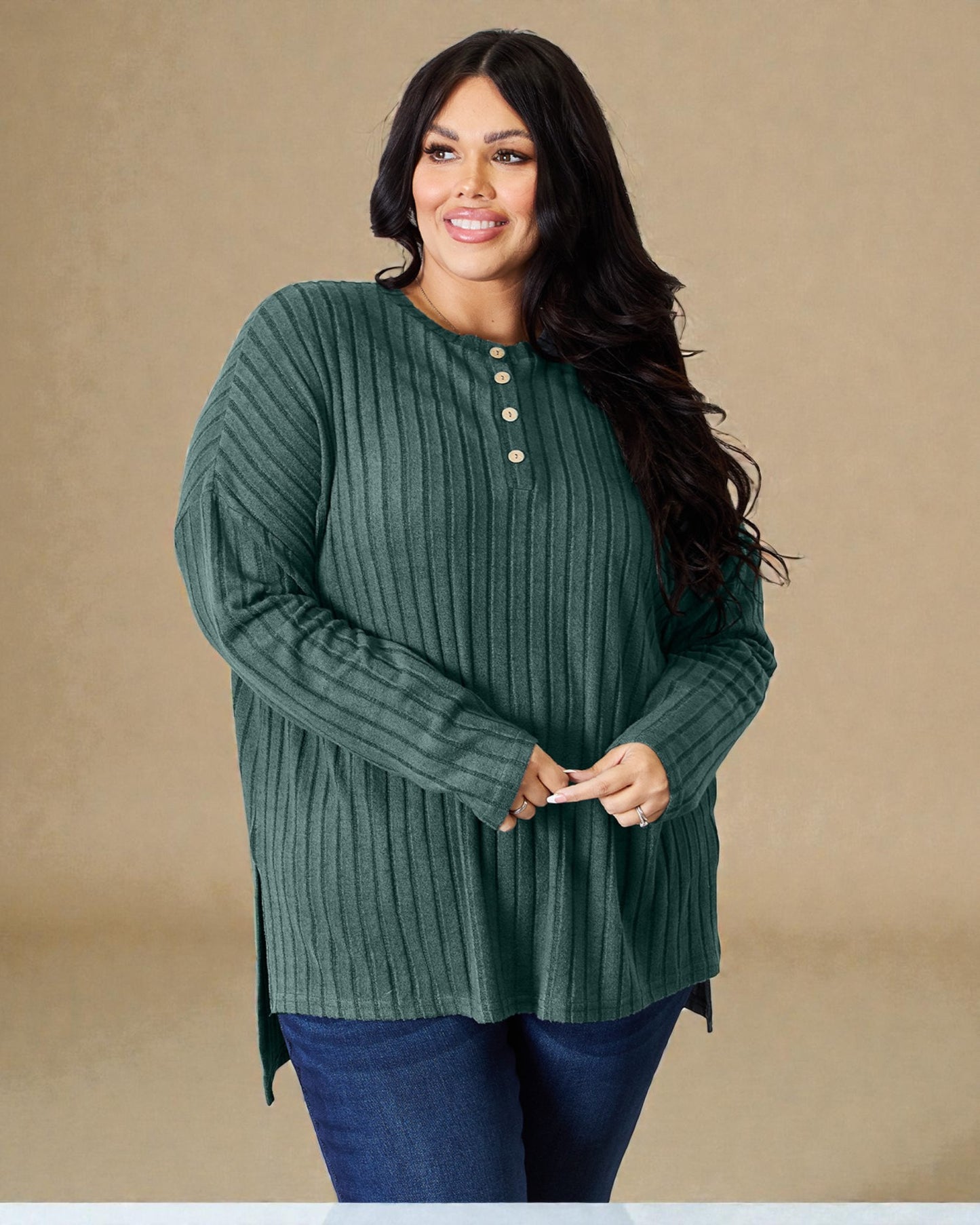Woman wearing a green ribbed sweater with buttons on a beige background