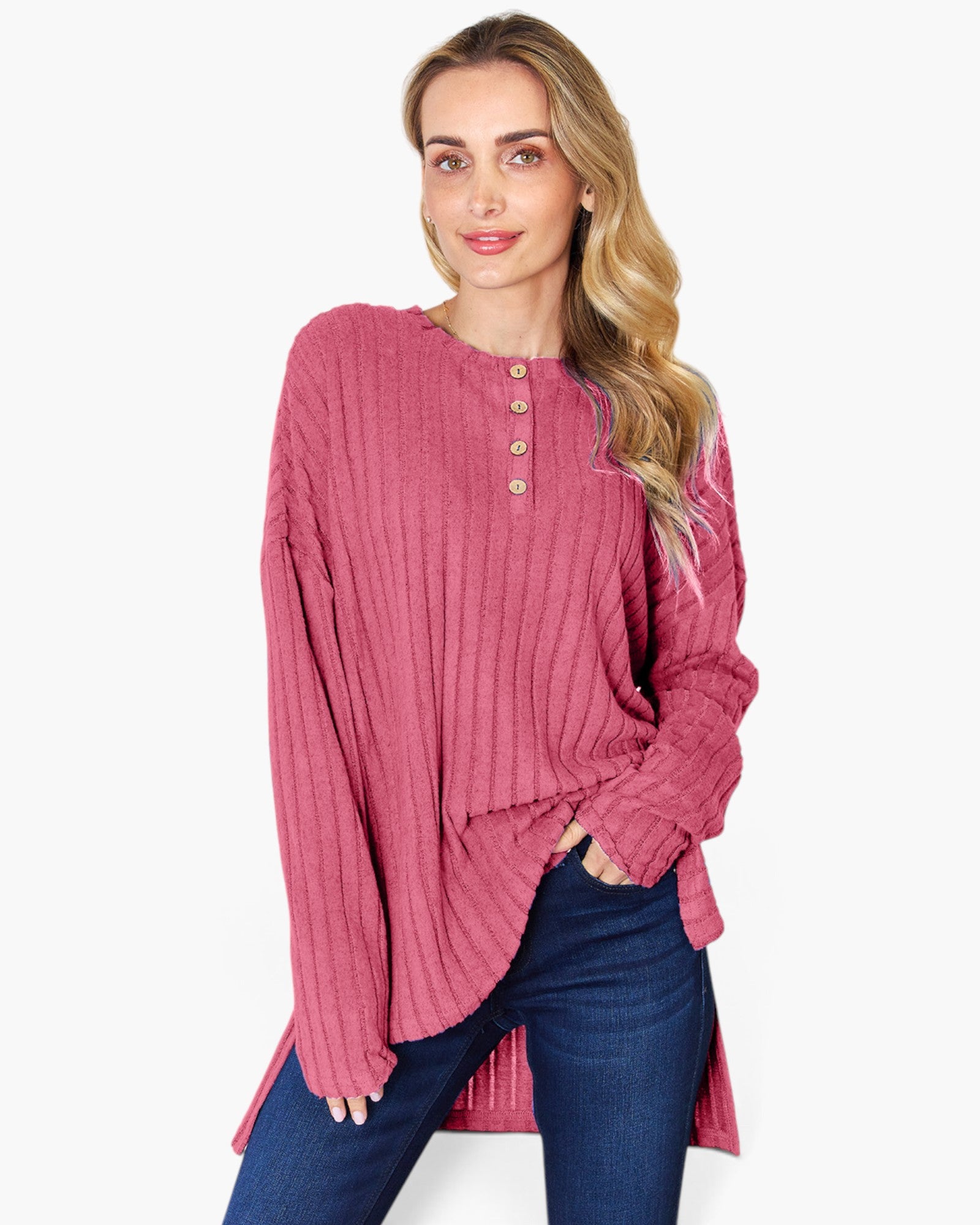 A woman modeling a dusty rose ribbed knit long-sleeve henley top with gold buttons, paired with dark blue jeans, against a plain white background.