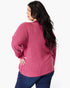 A woman wearing a ribbed knit sweater in a dusty rose pink color, shown from a back-three-quarter view against a plain white studio background.