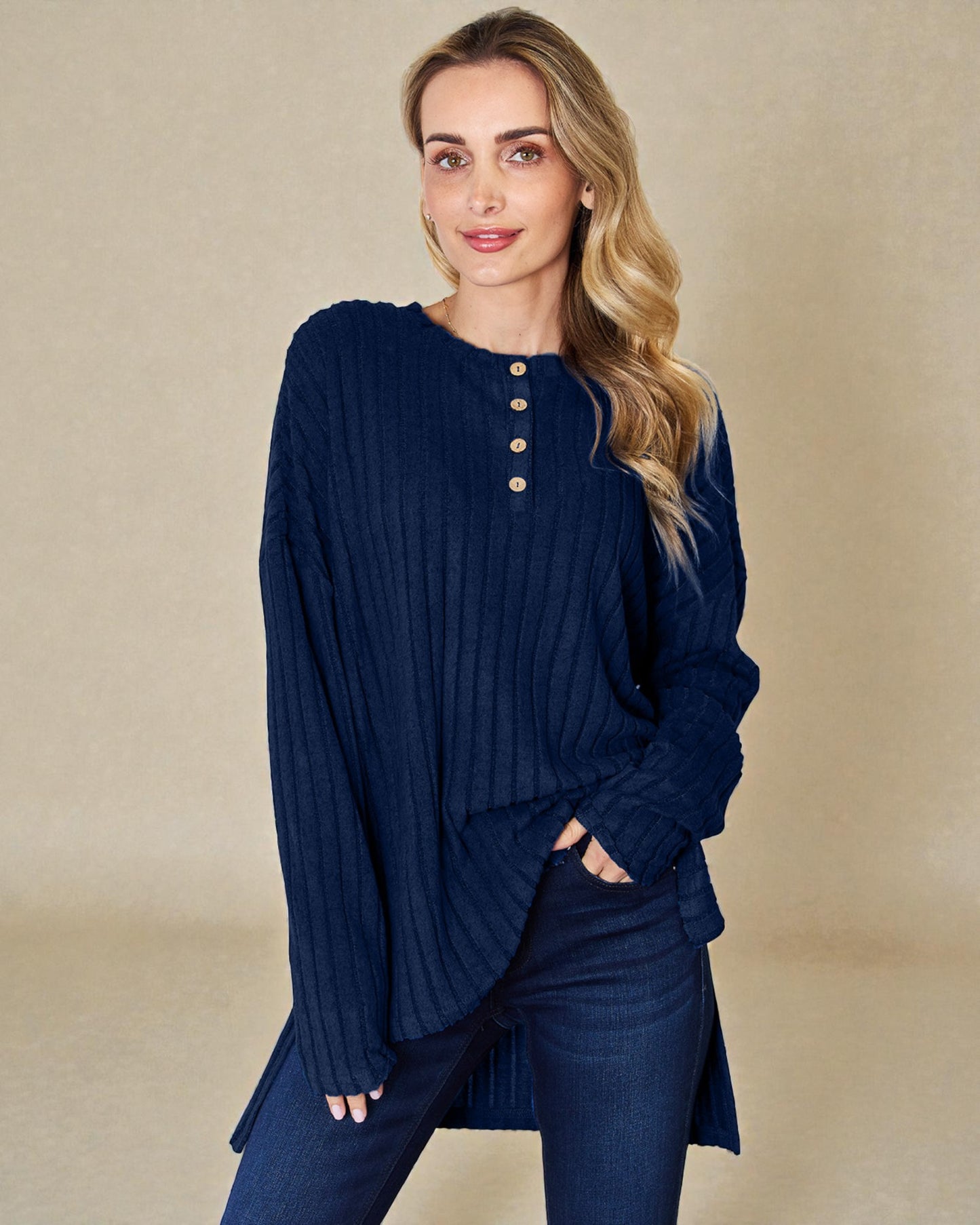 Woman wearing a navy blue ribbed sweater and pants on a beige background