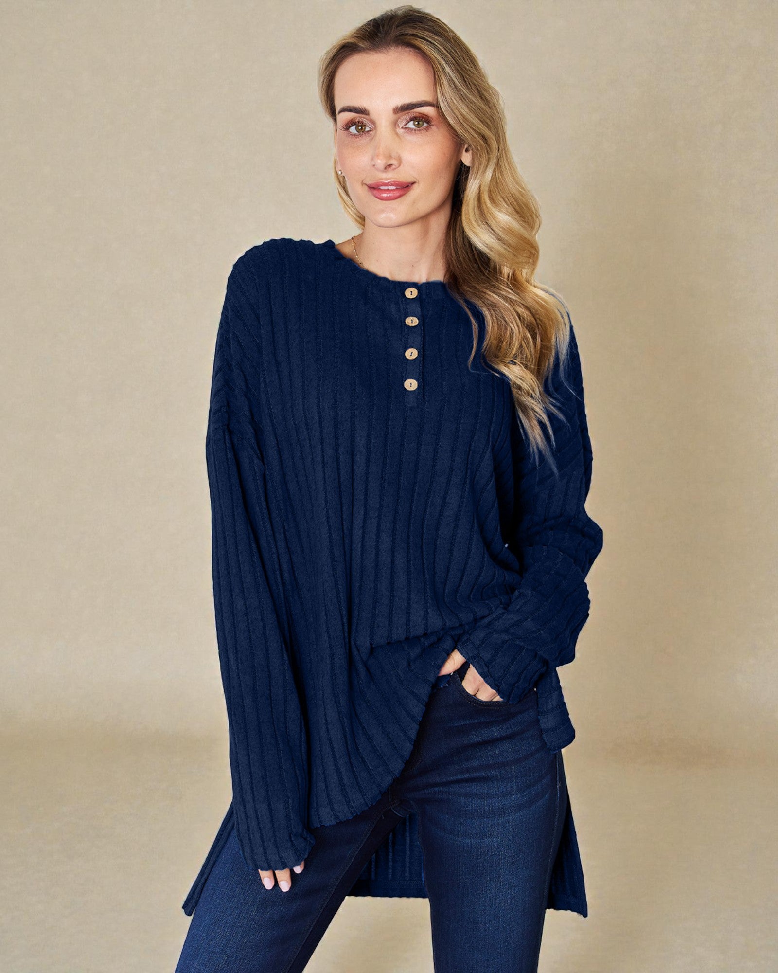 Woman wearing a navy blue ribbed sweater and pants on a beige background