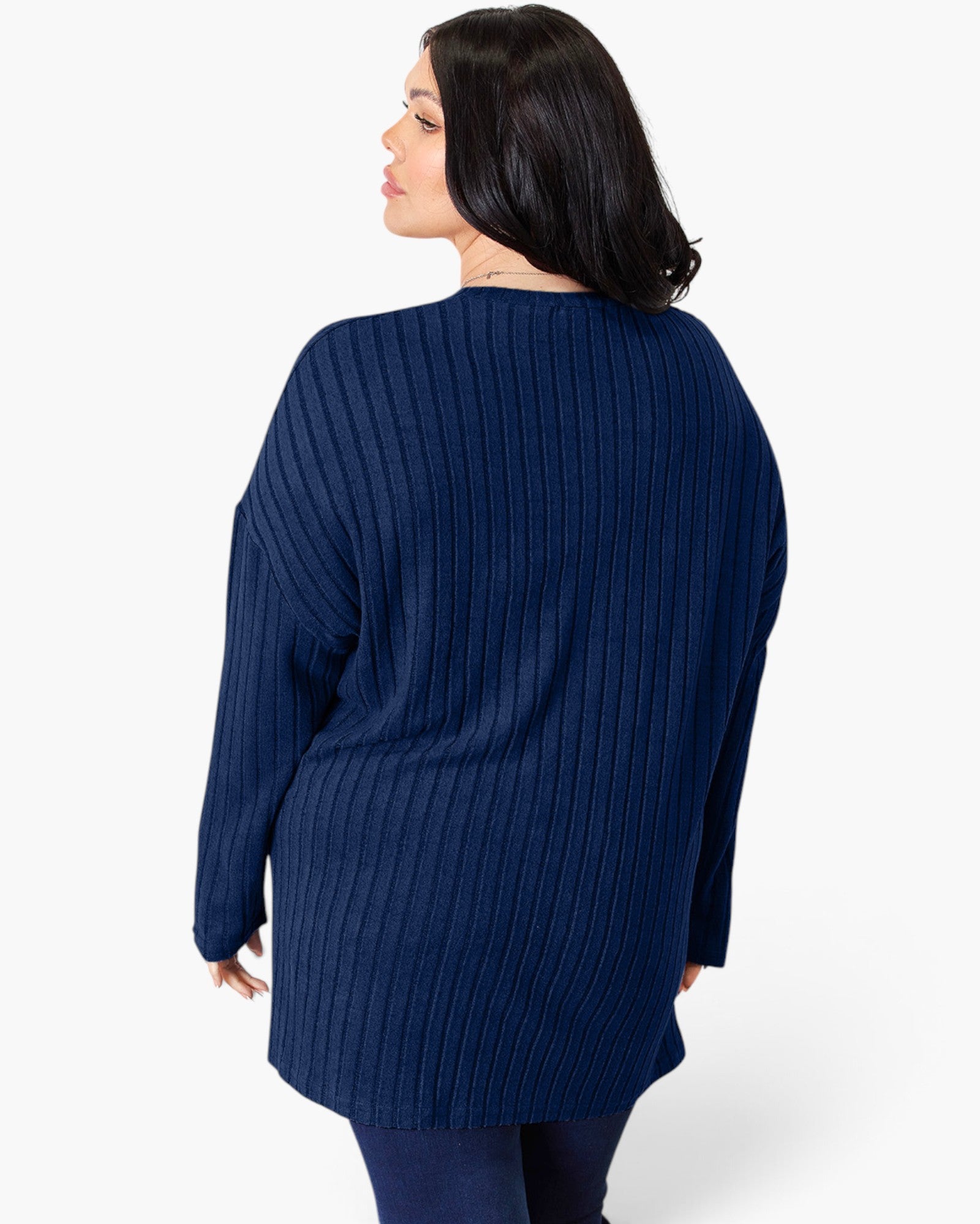 A woman shown from the back wearing a navy blue ribbed knit sweater, photographed against a clean white studio background.