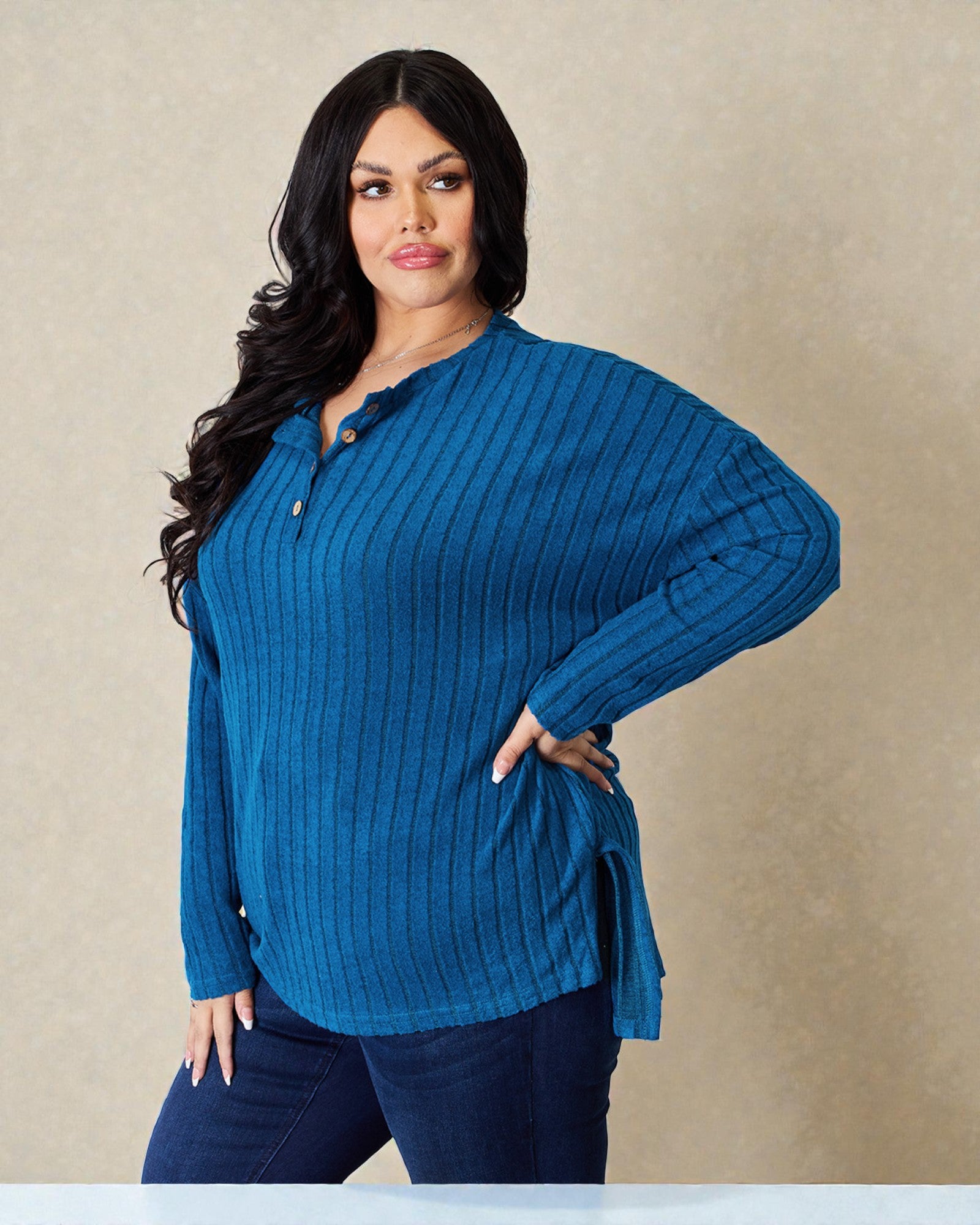 Woman wearing a blue ribbed sweater against a beige background